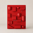 Red wall-mounted organizer with various shaped compartments on a beige background