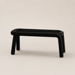 Black rectangular stool on a beige background