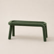 Green stool with curved legs on a beige background