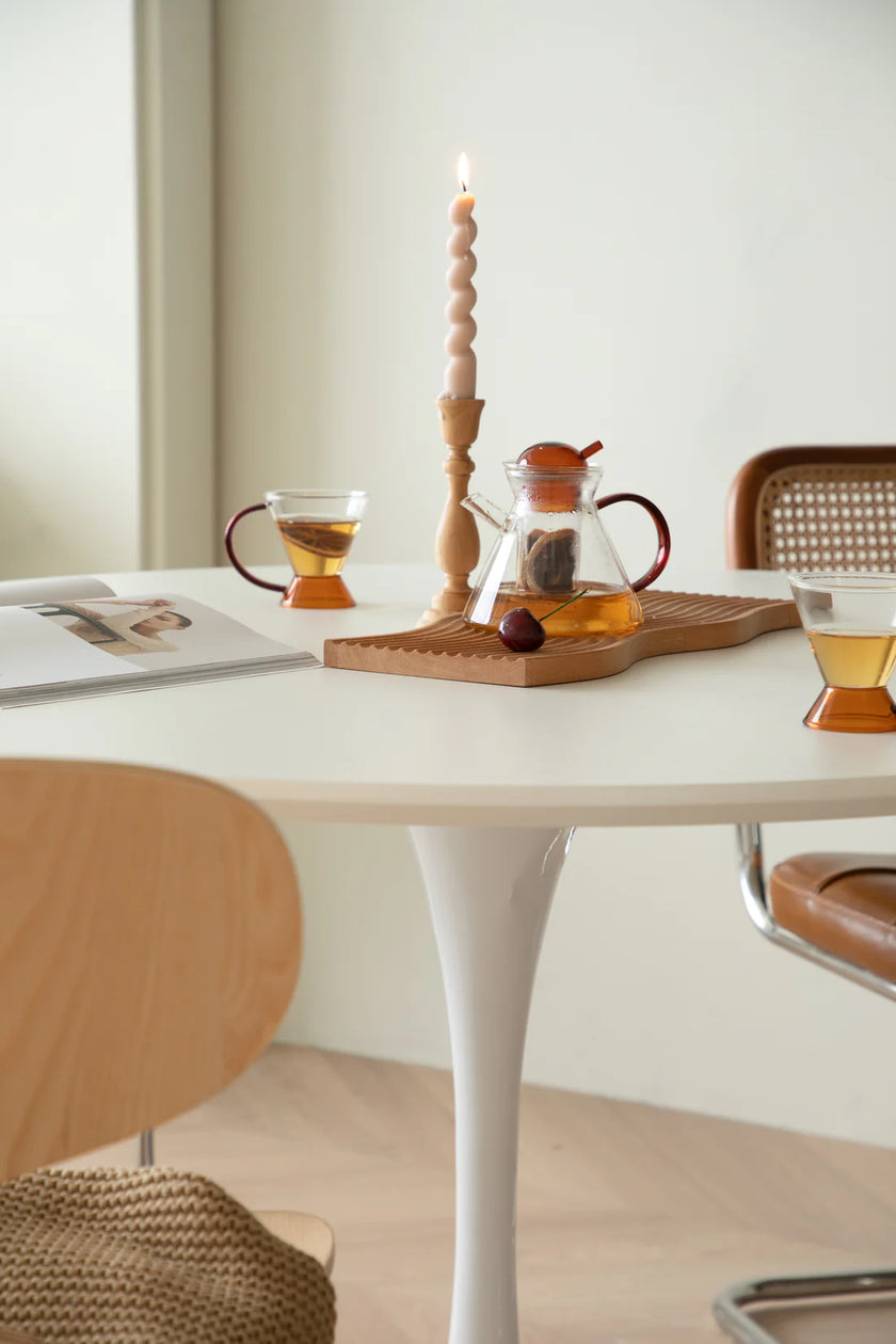 Tea set on a white round kitchen table
 table with a candle and magazine