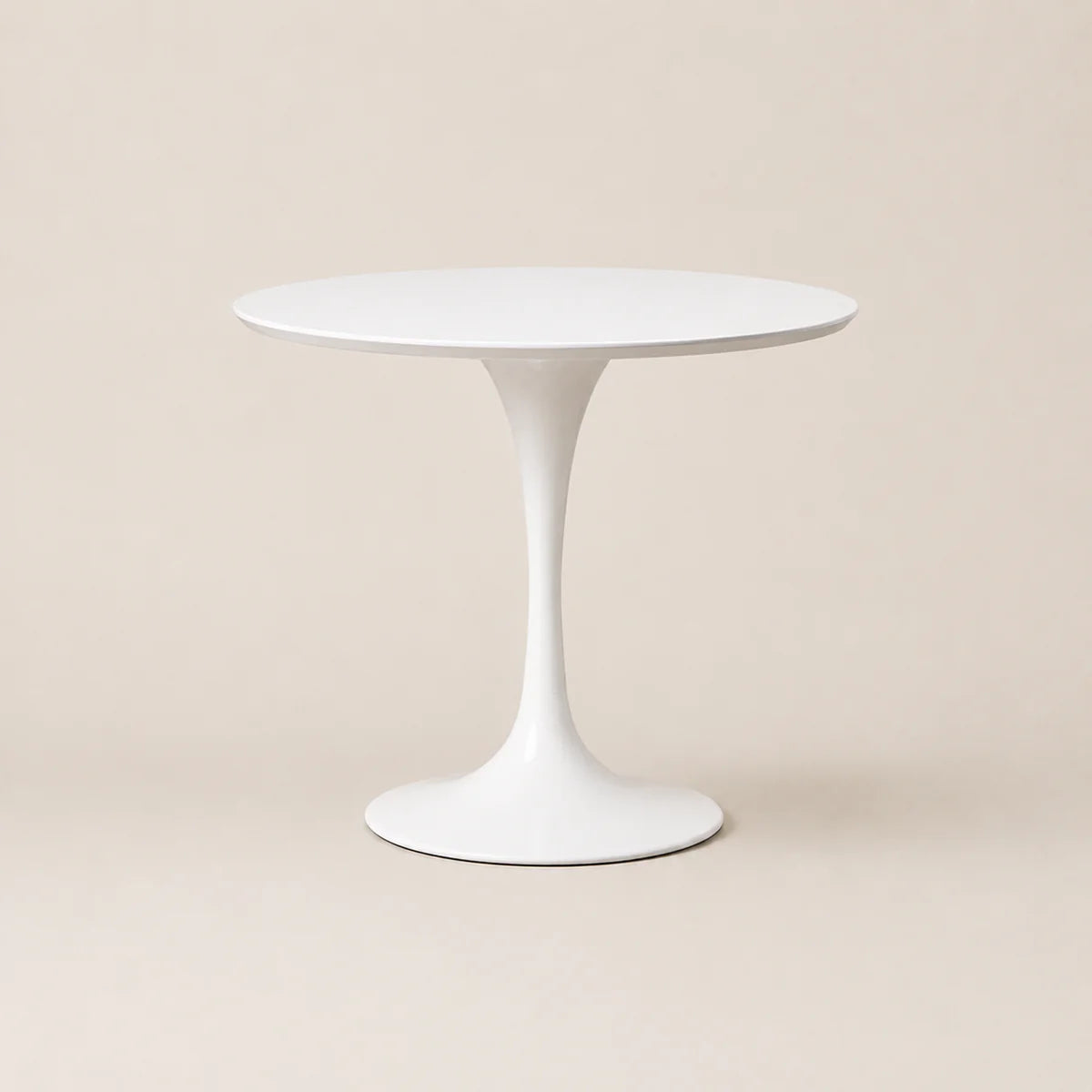 White round table with a slender pedestal base on a beige background