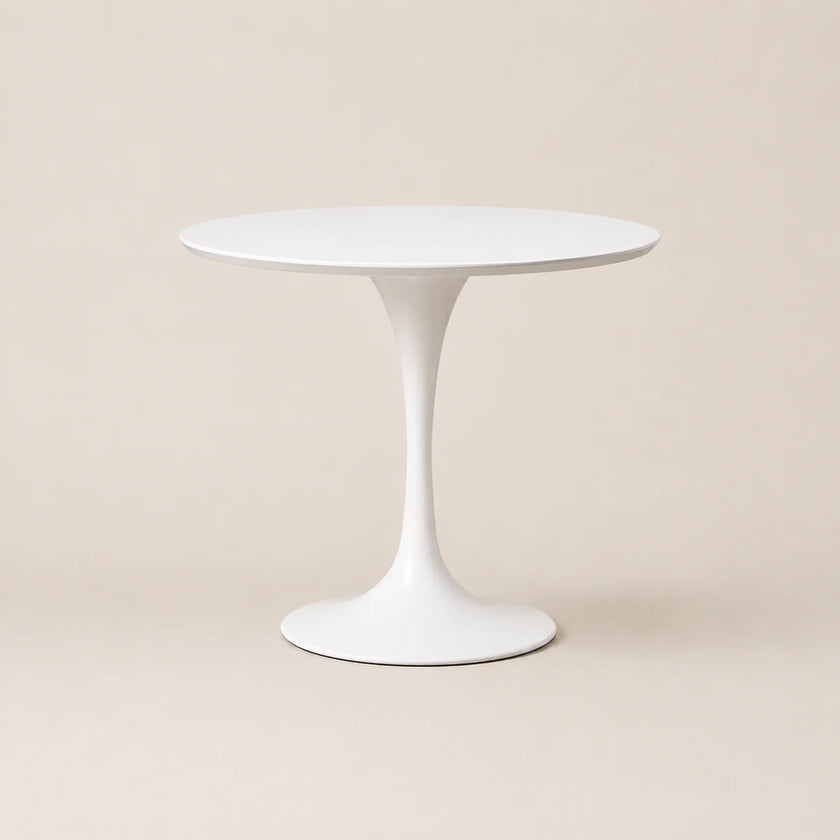 White round table with a slender pedestal base on a beige background