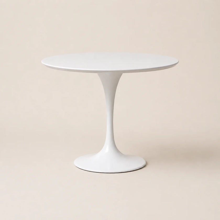 White round table with a pedestal base on a beige background