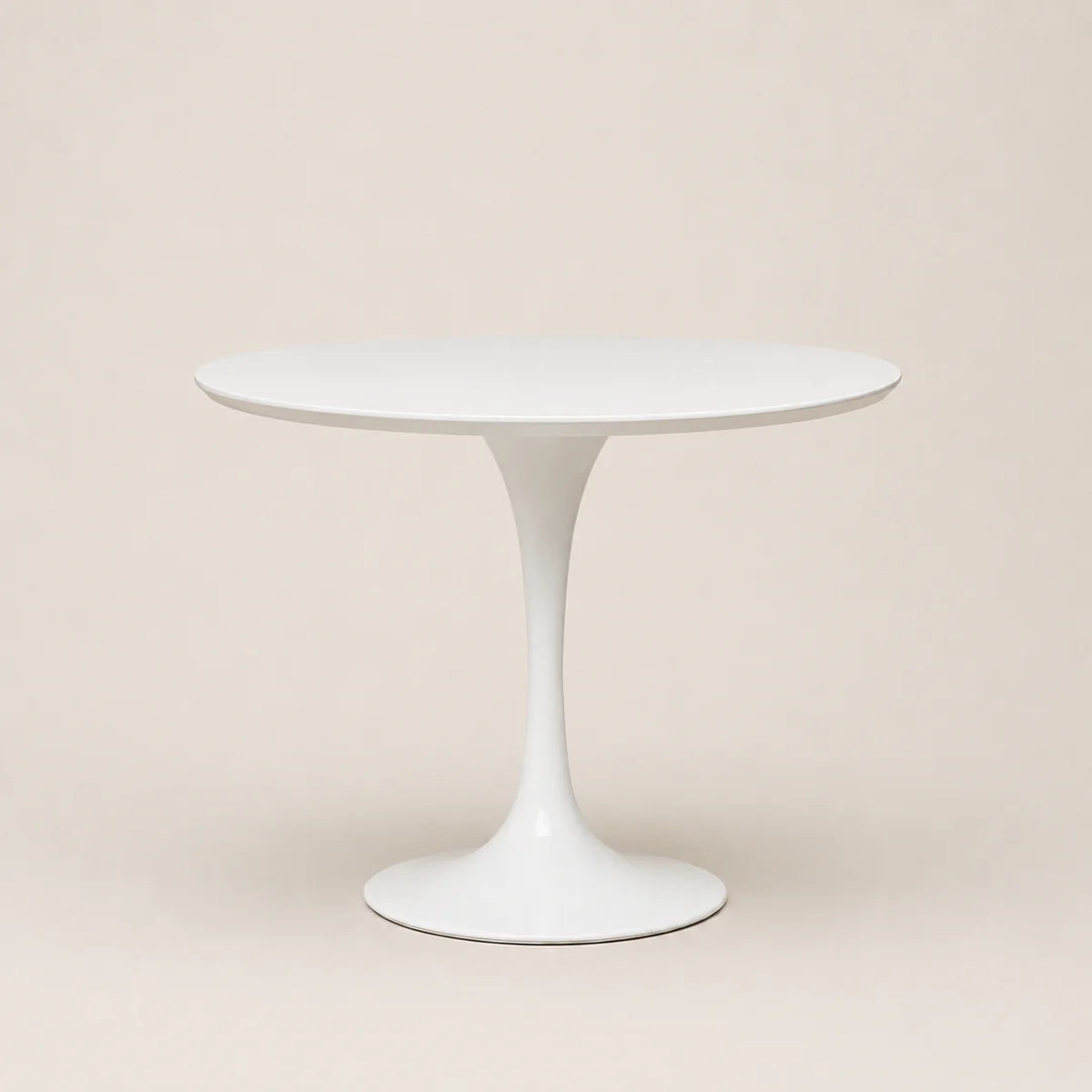 White round table with a pedestal base on a beige background
