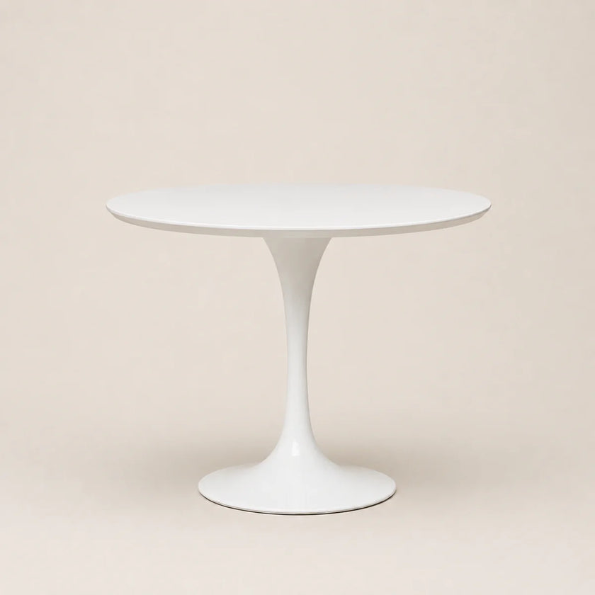 White round table with a pedestal base on a beige background