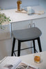 Gray counter height bar stools in a kitchen setting with a counter and decor items.
