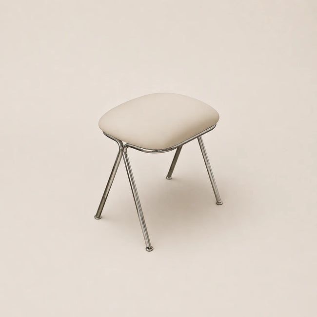 Stool with a cushioned seat and metal legs on a beige background