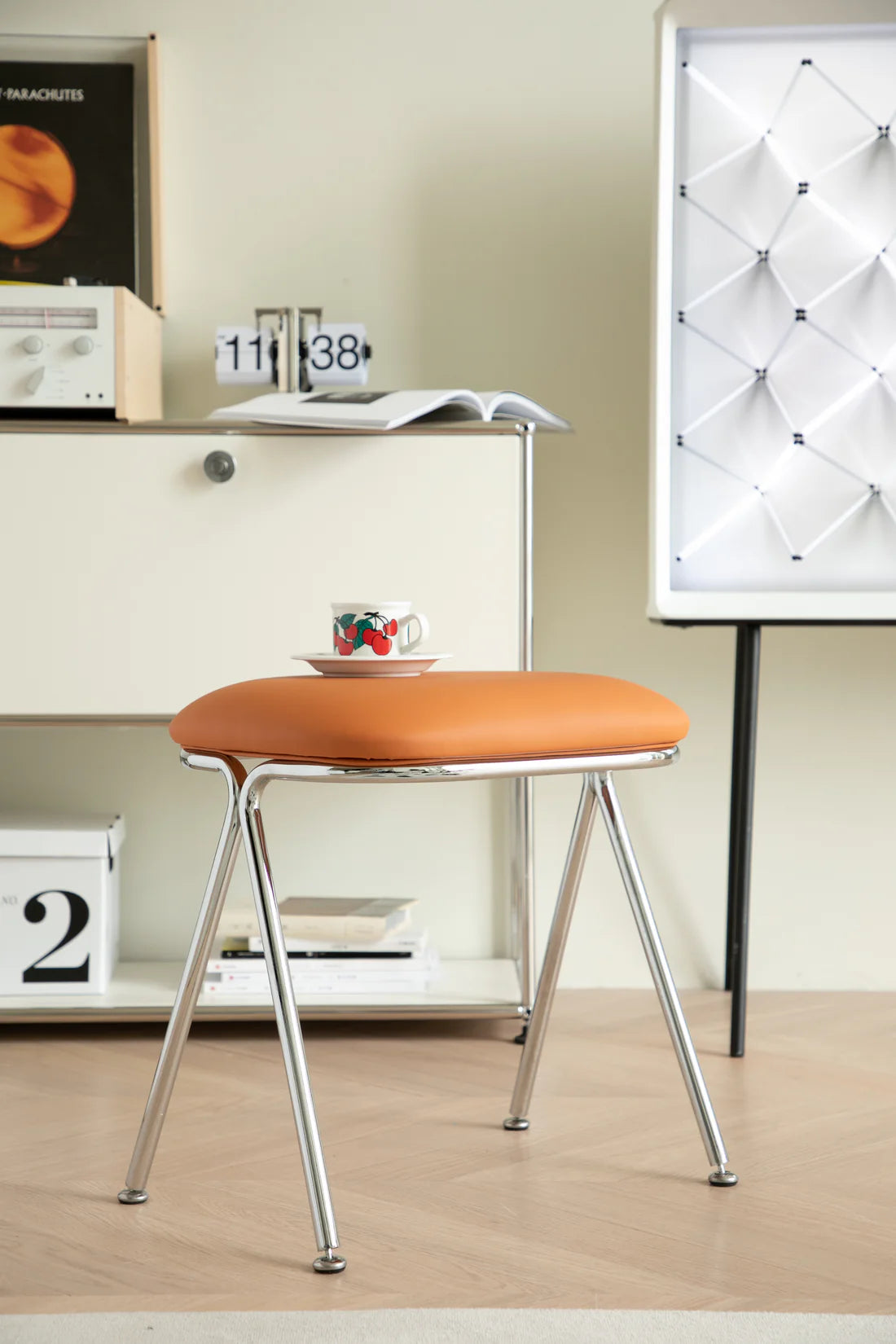Orange vanity stool with metal legs in a room setting
