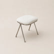 White stool with metal legs on a beige background