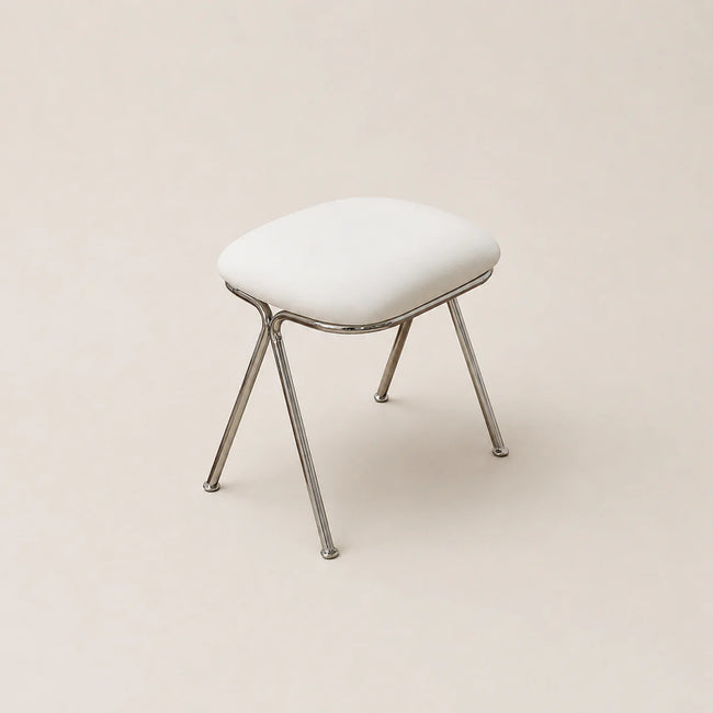 White stool with metal legs on a beige background