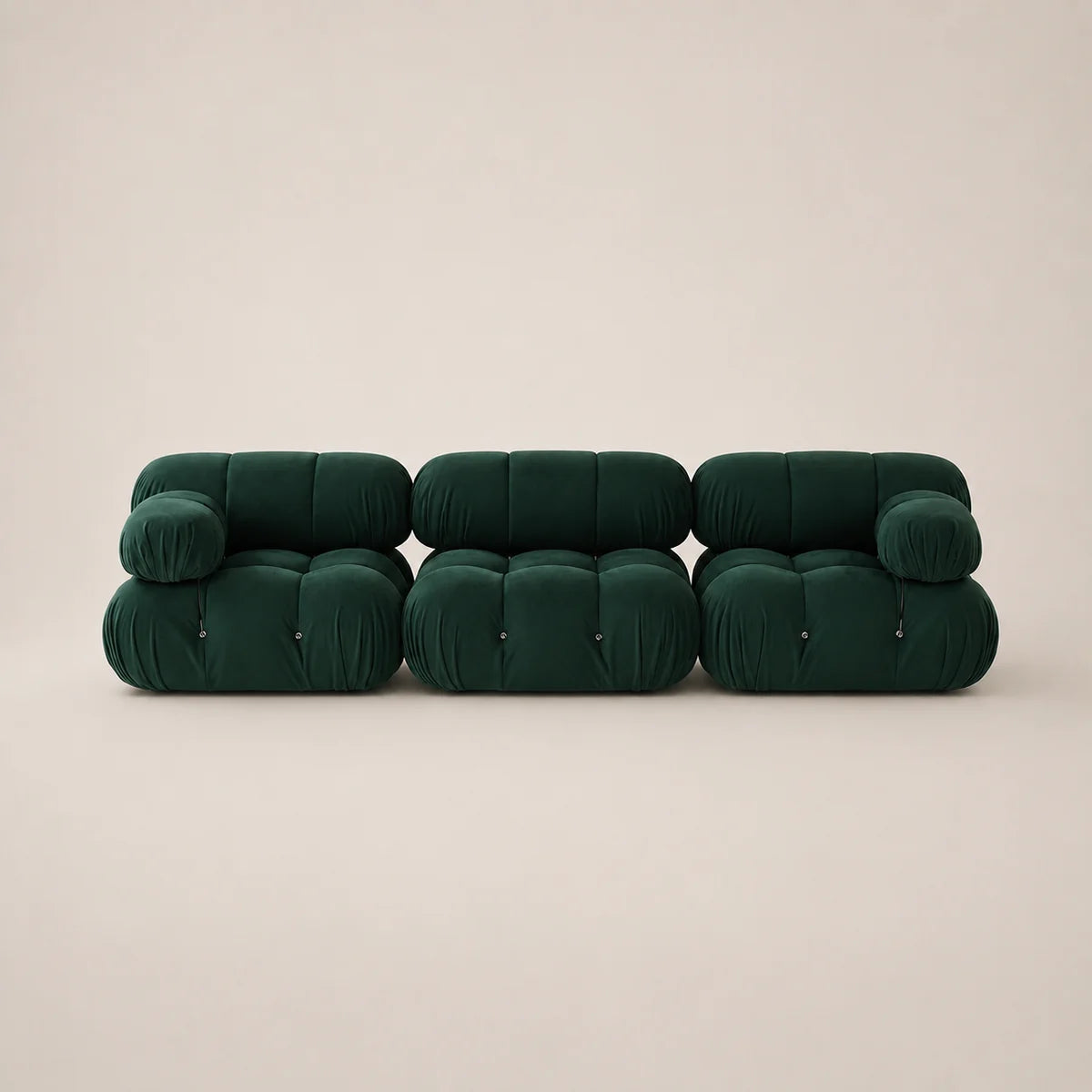 A modern three-seater sofa upholstered in dark forest green velvet, featuring a unique segmented, bubble-like design with cylindrical cushions, set against a solid warm beige background.