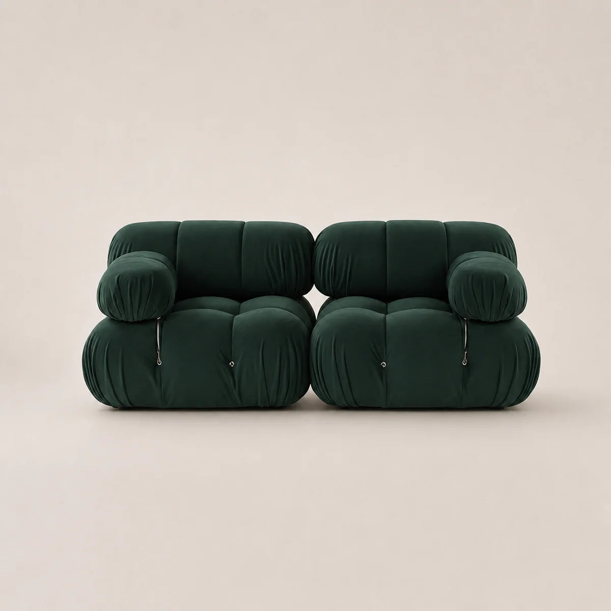 A pair of forest green modular upholstered armchairs with a rounded, cloud-like design and zippered front details, set against a solid light beige background.
