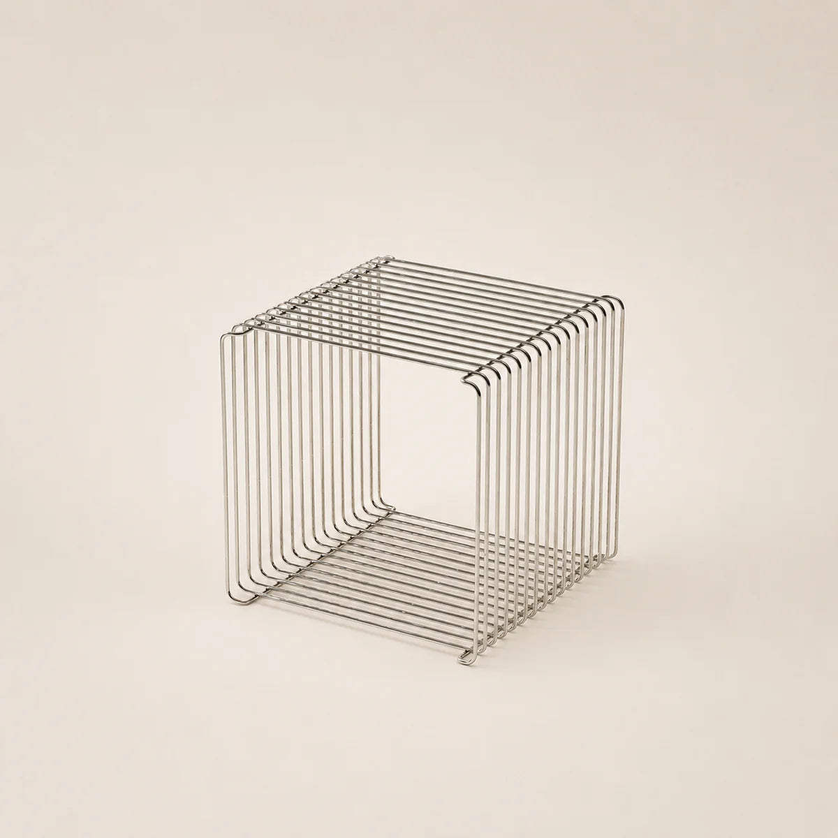 Wire mesh cube on a beige background