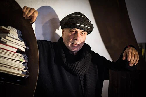 Man holding a stack of books with a plain background