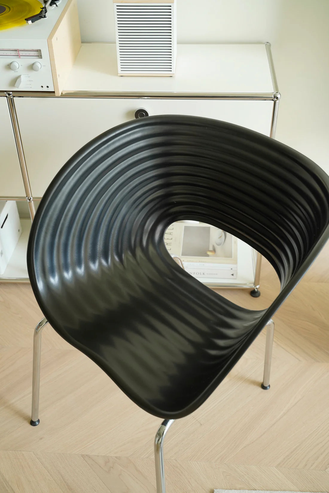 Black wavy living room chair in a room with a desk and computer monitor.