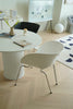 Modern dining area with a round white table and dining chairs in a minimalistic room.