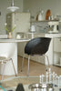 Modern kitchen with black dining chair, white refrigerator, and various appliances.
