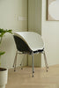 Modern plastic dining chair with a white backrest and black seat in a minimalistic room.