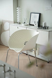 Modern interior with a white living room chair and a sideboard in a minimalistic room.