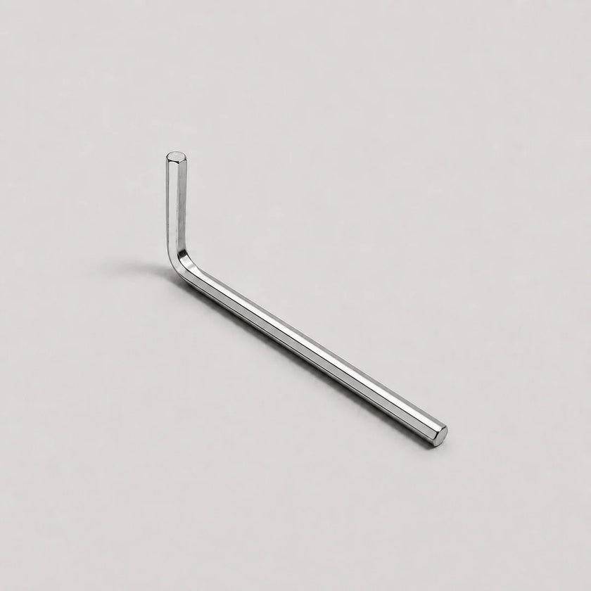 A silver metal hex wrench with an L-shaped head, shown diagonally on a light gray background.