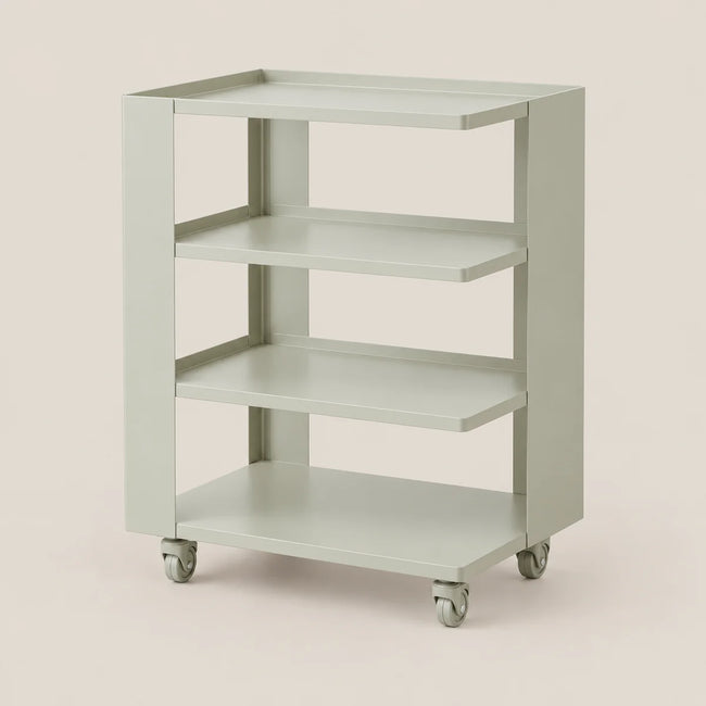 A three-tier rolling utility cart in a light sage green color, featuring a flat top shelf and three intermediate shelves, mounted on gray caster wheels against a solid light beige background.
