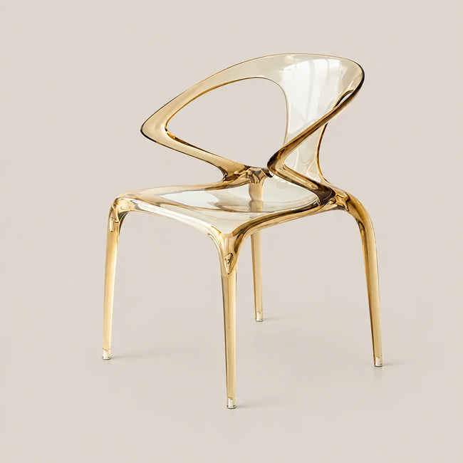 A modern translucent acrylic dining chair with a glossy gold-finished metal frame, shown against a solid light beige background.
