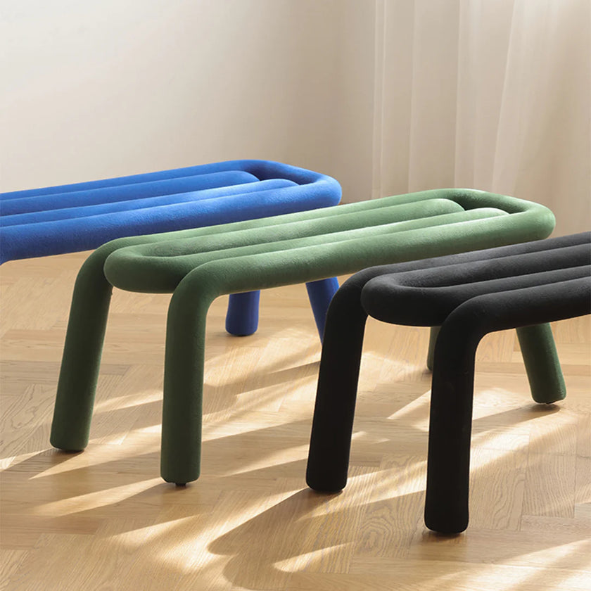 Three colorful stools (blue, green, black) on a wooden floor.
