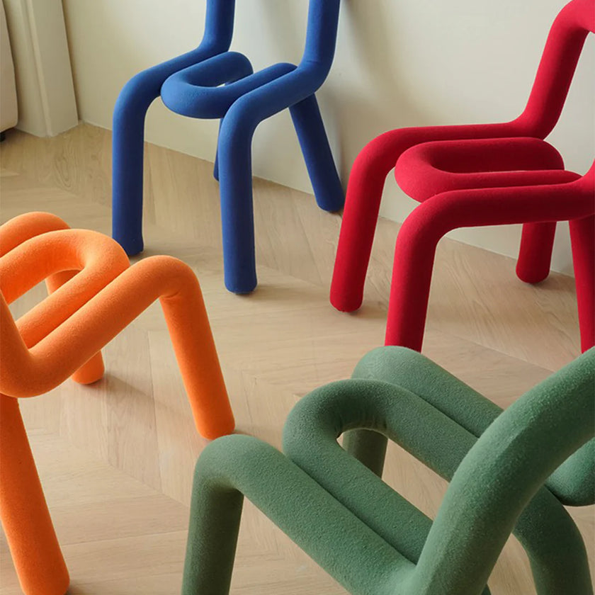 Colorful chairs in blue, red, orange, and green on a wooden floor.