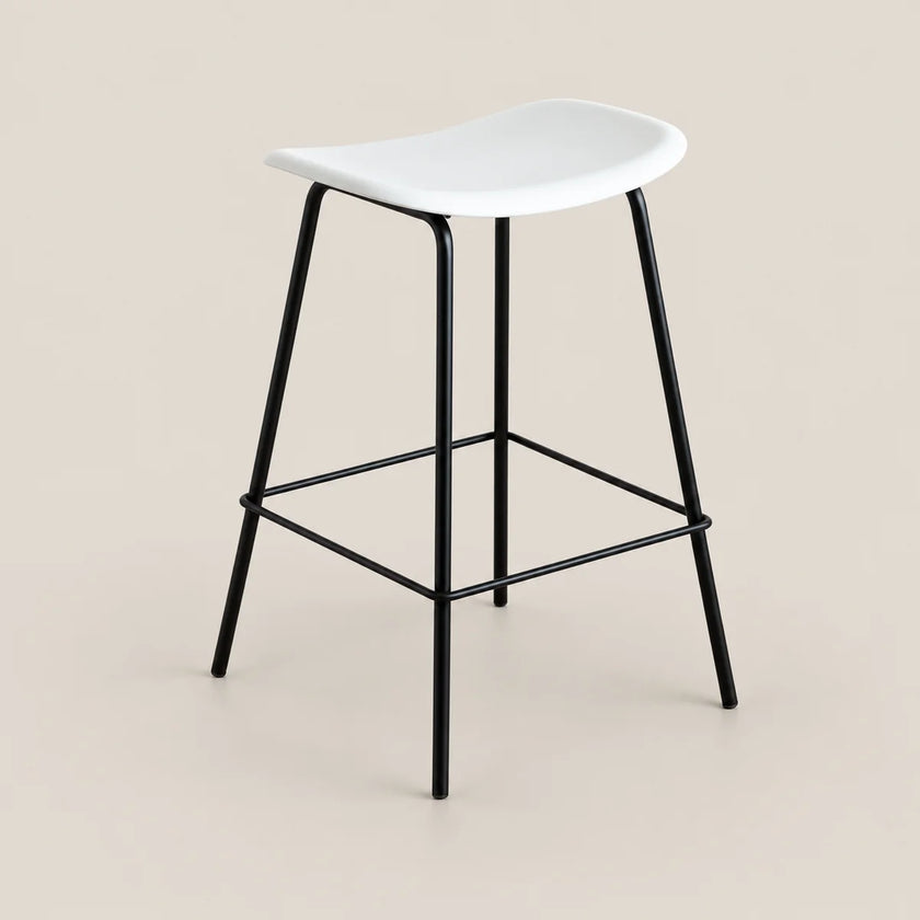 A modern counter stool with a white molded seat and a black metal frame with a footrest, set against a solid beige background.
