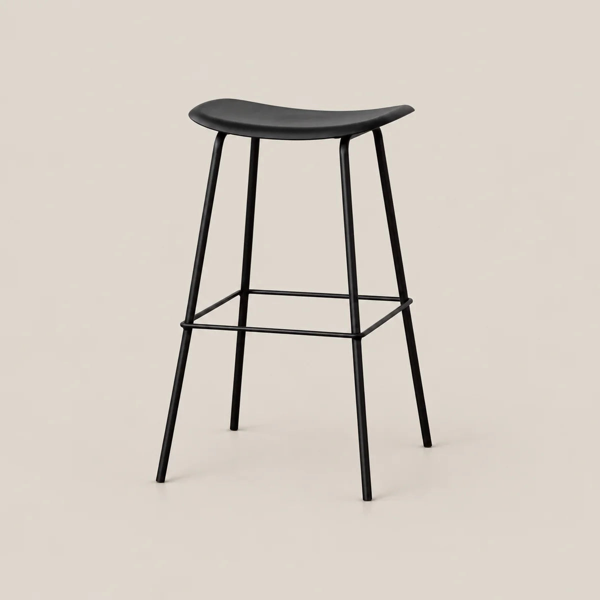 A modern black bar stool with a curved seat, slim metal legs, and a footrest, shown against a solid light beige background.