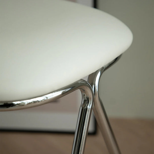 Close-up of a white chair with chrome legs on a neutral background
