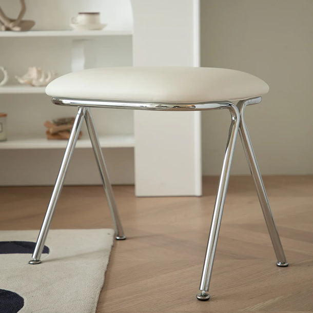 White stool with metal legs on a wooden floor