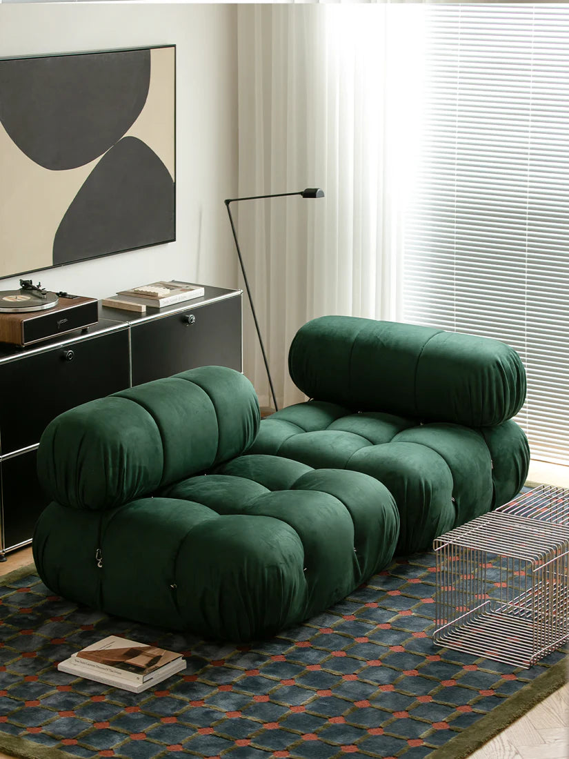 Green modular sofa in a modern living room with abstract art and a rug.