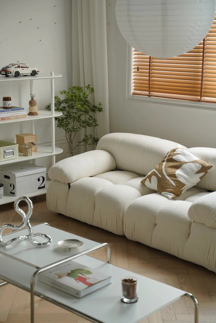 Modern living room with a white sofa, coffee table, and decorative items.