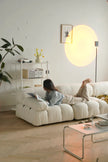 Woman reading a book on a white sofa in a modern living room.