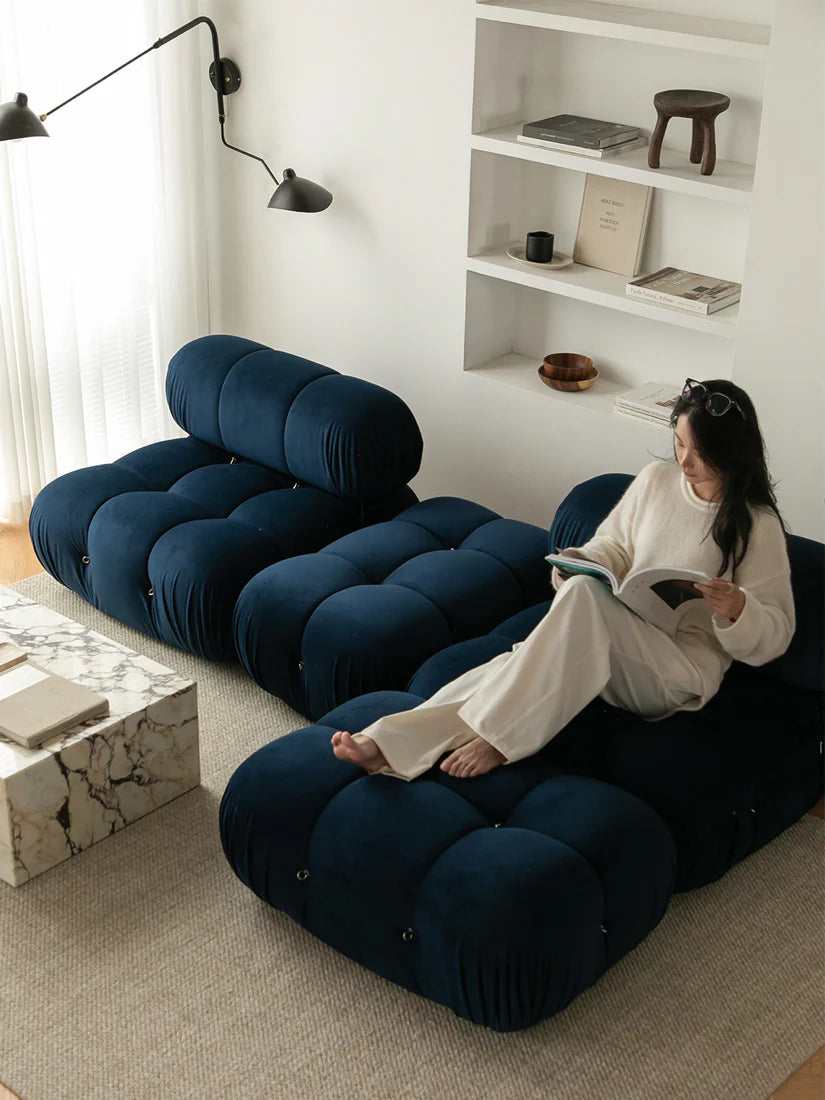 Person sitting on a blue modular sofa in a modern living room.