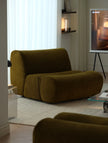 Brown armchair in a modern living room with a TV in the background