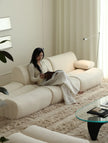 Woman sitting on a modern white sofa in a stylish living room.