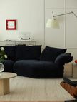 Modern living room with a dark blue sofa, light-colored walls, and minimal decor.