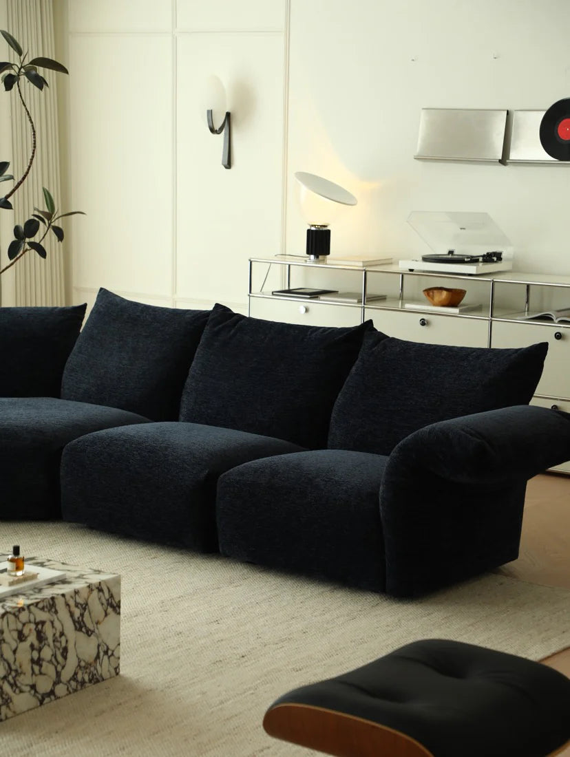 Modern living room with a dark blue sofa and decorative items.
