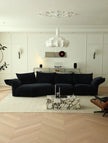 Modern living room with a black sofa, marble coffee table, and decorative wall art.