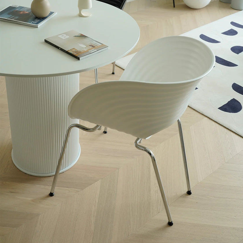 White chair and table set on a wooden floor with a rug in the background