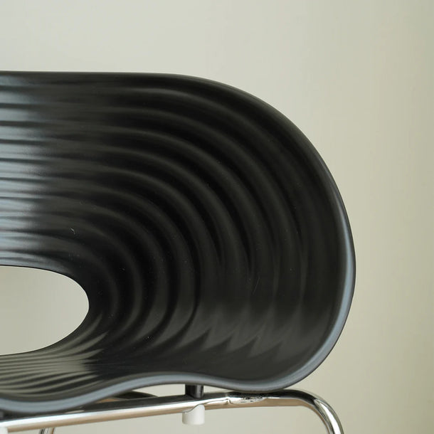 Close-up of a black wavy chair with a neutral background