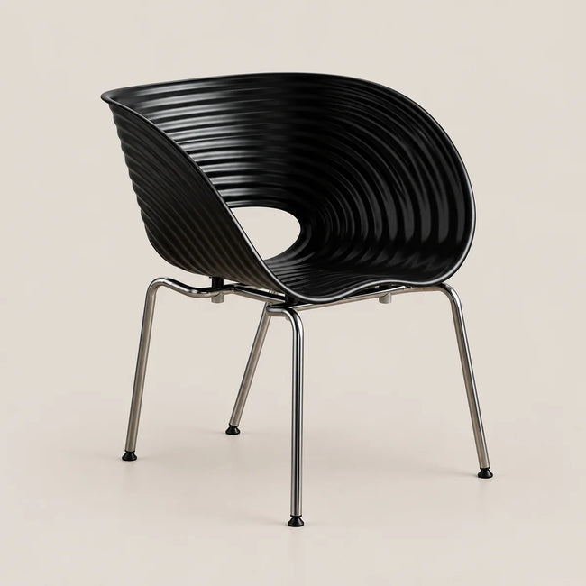 A modern black molded plastic chair with a ribbed, wave-like backrest and slim chrome legs, shown against a solid light beige background.