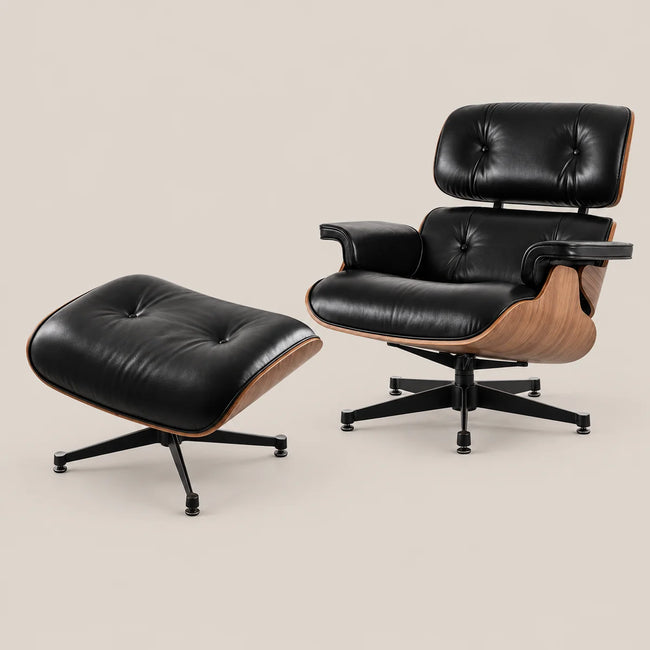 A modern lounge chair with matching ottoman in black leather and natural wood, shown on a light beige studio background.